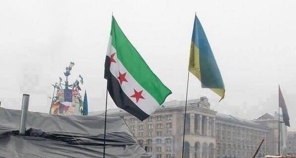 Det gamle franske koloni-flag for Syrien, der idag anvendes af den såkaldte syriske opposition. Her ved siden af Ukraines flag i Kiev med EU's flag i baggrunden. 