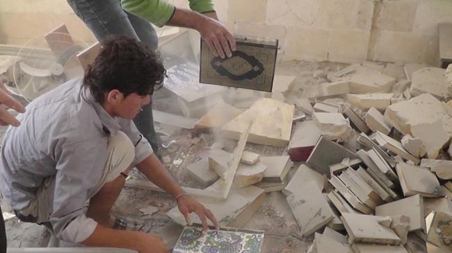 Lokale redder Koranen fra den ødelagte Husseiniya-moske i Idlib efter angrebet. 